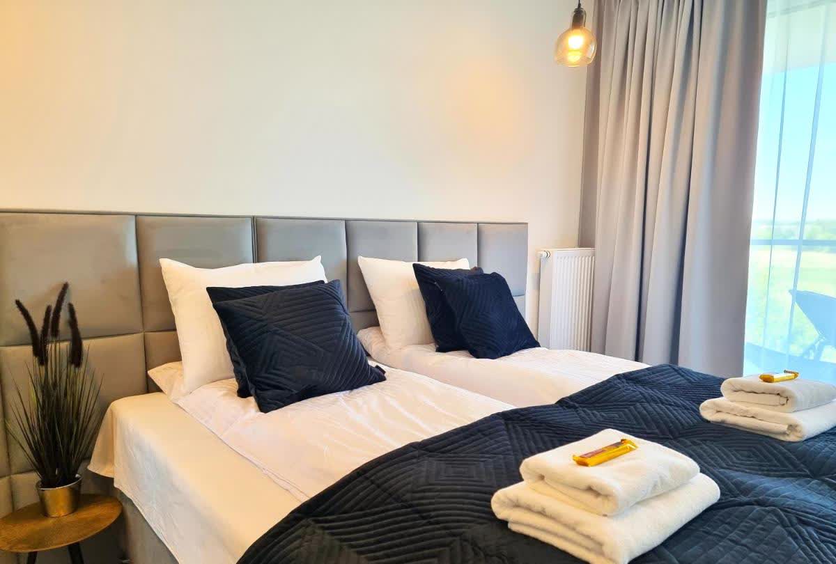 Apartment mit grauem Paneel-Kopfteil und zwei Einzelbetten