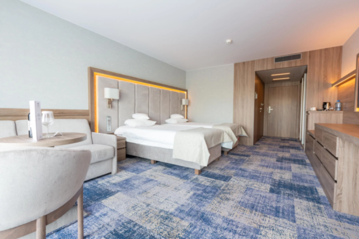 Helles Hotelzimmer mit Bettbox und Kopfteil in Sandtönen